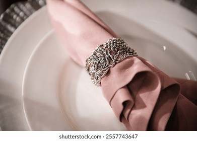 Wedding set up, dinner table reception. Plate decorated linen pink napkin. Serving, setting table. Birthday, baptism, event. Luxury silver decor. Side view. Closeup.