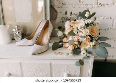 Wedding shoes and wedding paraphernalia, wedding gold rings, wedding bouquet on the table
