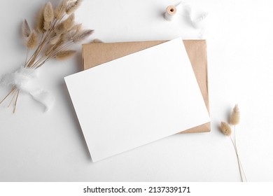 Wedding stationery invitation card mockup 7x5 on white background with envelop and boho decor. Baby shower o bridal shower mockup. Minimal bohemian style blank mockup, thank you card, greeting card