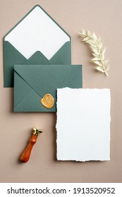 Wedding Stationery Set Top View. Flat Lay Blank Invitation Card Mockup, Green Envelopes, Wax Seal Stamp, Dried Flowers.