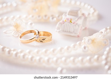 Wedding still life with golden rings and pearl necklace in white - Powered by Shutterstock