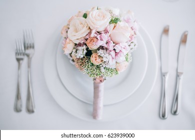 A wedding table is a bouquet on a dish and flatwares