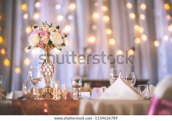 wedding\
table with exclusive floral arrangement prepared for reception,\
wedding or event centerpiece in rose gold\
color