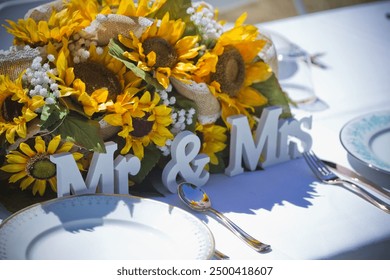 a wedding table setting decorated with bright yellow sunflowers and a 