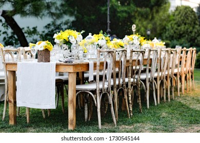 Wedding Table Setting On A Long Wood Table With Yellow Flowers