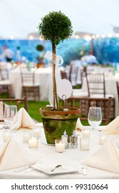 A Wedding Table In White With A Large Sculptured Centerpiece In A Pot