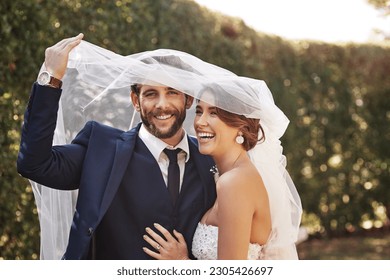 Wedding, veil and couple with love, marriage and celebration for relationship, loyalty and commitment. Portrait, bride or groom with a smile, married or cover with dress with happiness in a garden