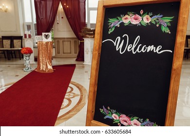 wedding welcome board with space for text. rustic wooden wall with flowers, photo booth, decorated backdrop and empty chalkboard. wedding reception and ceremony