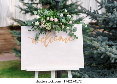 Wedding white Board Mockup easel with welcome sign decorated with flowers, outdoors. Greeting card template