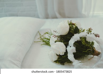 Wedding White Bridal Veil & Rose Flower Bouquet On Bed Beside See Through Sheer Window Curtain