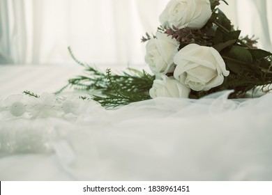 Wedding White Bridal Veil & Rose Flower Bouquet On Bed Beside See Through Sheer Window Curtain