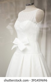 Wedding White Dress Bridal Gown In Store Window On Clothes Mannequin.