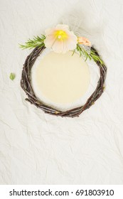 wedding wreath with mallow flower and rosemary twigs on creased beige textile background