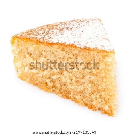 Wedge of lemon sponge cake with icing sugar topping isolated on white.