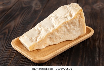 Wedge Of Parmesan Cheese On Wooden Background