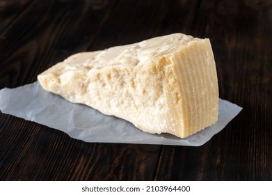 Wedge Of Parmesan Cheese On Wooden Background