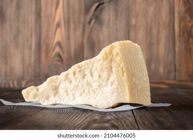 Wedge Of Parmesan Cheese On Wooden Background