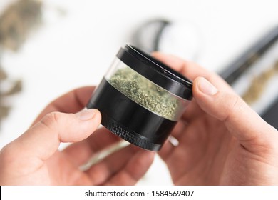 Weed grinder Fresh marihuana in hand. Cannabis buds on white wood background. Copy space. Close up. CBD and THC on buds in cannabis.