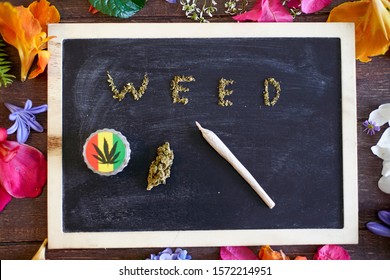 WEED Message Made By Marijuana On A Blackboard With A Grinder, A Piece Of Weed And A Rolled Joint On It.   