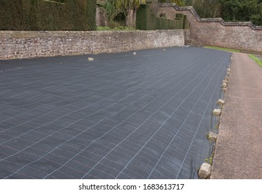 Weed Suppressant Fabric Covering a Bed in a Walled Organic Vegetable Garden in Rural Devon, England, UK