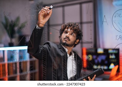 Week plan, to-do list, scrum planning, sprint concept. Young bearded businessman creates tasks, checks progress and working with transparent glass board for project management