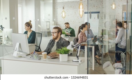 Weekday In A Busy Creative Bureau. Office People Working At Their Personal Computers, Talking On The Phone. At Conference Table Business Discussion Is Happening.