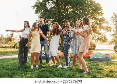 Weekend activities. Group of young people have a party in the park at summer daytime. - Shutterstock ID 2276353693