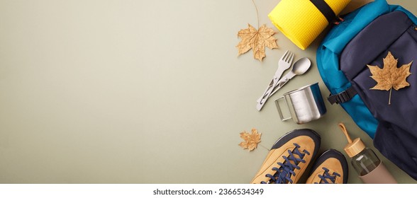 Weekend excursion into the natural world. Top view photo of metal utensils, hiking boots, backpack, trekking sticks, karemat, water bottle, autumn leaves on green background with advert zone - Shutterstock ID 2366534349