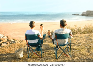 Weekend At Ocean. Senior Travelers Couple Sitting In Chairs Back To Camera And Drinking Coffee From Paper Cups, Looking At Beach And Sea Water Outside. Rear View Of Spouses Relaxing On Vacation - Powered by Shutterstock