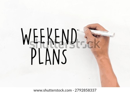Weekend Plans text written on whiteboard with marker. Leisure activities, travel planning, and free time concept.