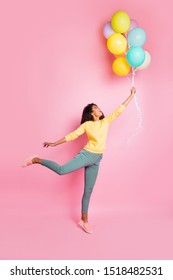 Weekend vacation freedom concept. Vertical full length photo of cute romantic lovely dreamy nice positive hipster in yellow jumper holding baloons want to fly up isolated pastel color background