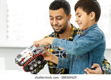 Weekends With Dad. Handsome Young Father And His Son Building A Toy Car Together Toys Educational Develop Intelligent Handy Fatherhood Parent Children Kids Family Happiness Concept Copyspace