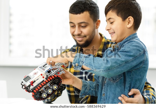 Weekends with dad. Handsome young father and\
his son building a toy car together toys educational develop\
intelligent handy fatherhood parent children kids family happiness\
concept copyspace
