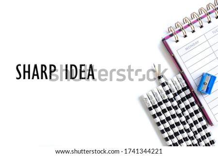 Weekly organizer planner, shaper and sharp pencil surrounded by dull pencils and words SHARP IDEA on white bakcground. Stationery flat lay. Business, sharp ideas concept