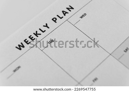 Weekly planner. Close-up of weekly plan paper for organizing schedule. Calendar reminder, planning concept, black and white 
