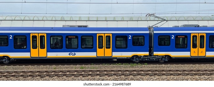 Weesp, the Netherlands - June 5, 2022: Side view of a Dutch public transport train standing in a railway station.