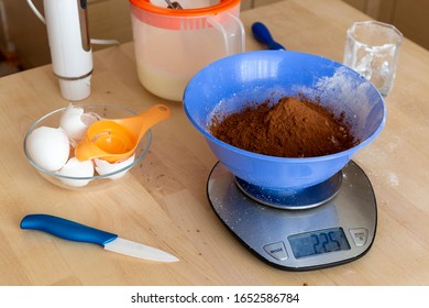 Weigh Flour And Cacao In A Bowl On A Kitchen Scale