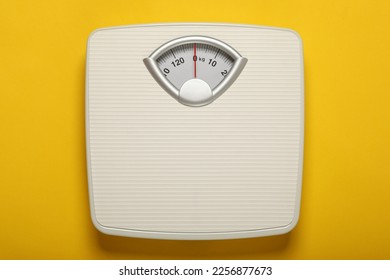 Weigh scales on yellow background, top view. Overweight concept - Shutterstock ID 2256877673