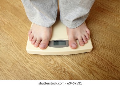 Weighloss - young man on a weighing scale - Powered by Shutterstock