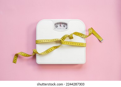Weight control concept. Weight scale and tape measure, top view