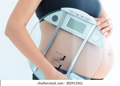 Weight Gain During Pregnancy With Pregnant Woman Holding Scale