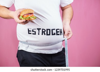 Weight Gain, Fast Food, Hormonal Imbalance, Estrogen Level. Overweight Man Belly With Hamburger And Measuring Tape