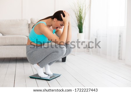 Weight Gain. Unhappy Woman Crying Standing On Weight-Scales Not Losing Weight On Diet Slimming At Home. Free Space