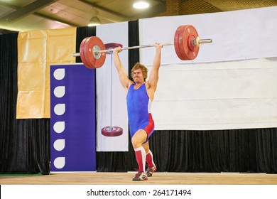 A weight lifter lifting weights during a competition