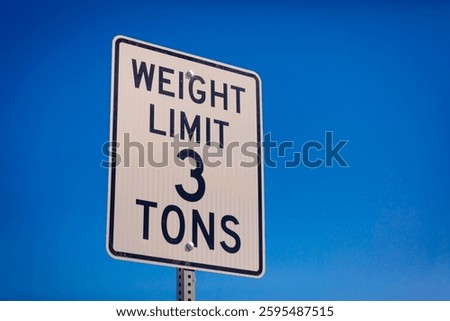 Weight Limit 3 Tons white metal sign on a side of a street, clear blue sky in the background, sunny day,  no people