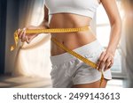 Weight lose concept. Slim young woman use tape measuring