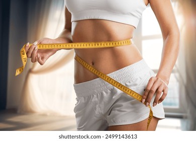 Weight lose concept. Slim young woman use tape measuring - Powered by Shutterstock