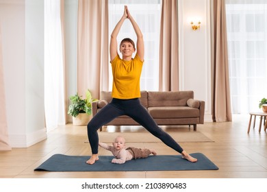 Weight Loss After Pregnancy. Happy yong mom training at home with her cute infant baby, practicing yoga. Beautiful woman smiling while doing postpartum recovery exercise with her charming toddler son