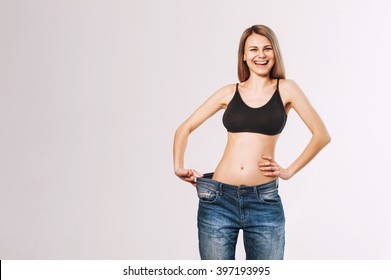 weight loss concept. thin girl and very happy. the girl began her big thing. Now she needs clothes smaller. jeans on her long. thin. a tall young girl in a black T-shirt. healthy skin.