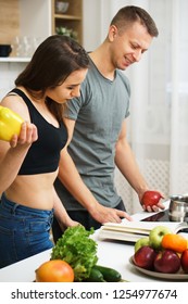 Weight Loss, Keto, Detox, Paleo Diet Food, Slimming And Healthy Lifestyle. Fit Slim Couple Reading Recipe Book Before Cooking